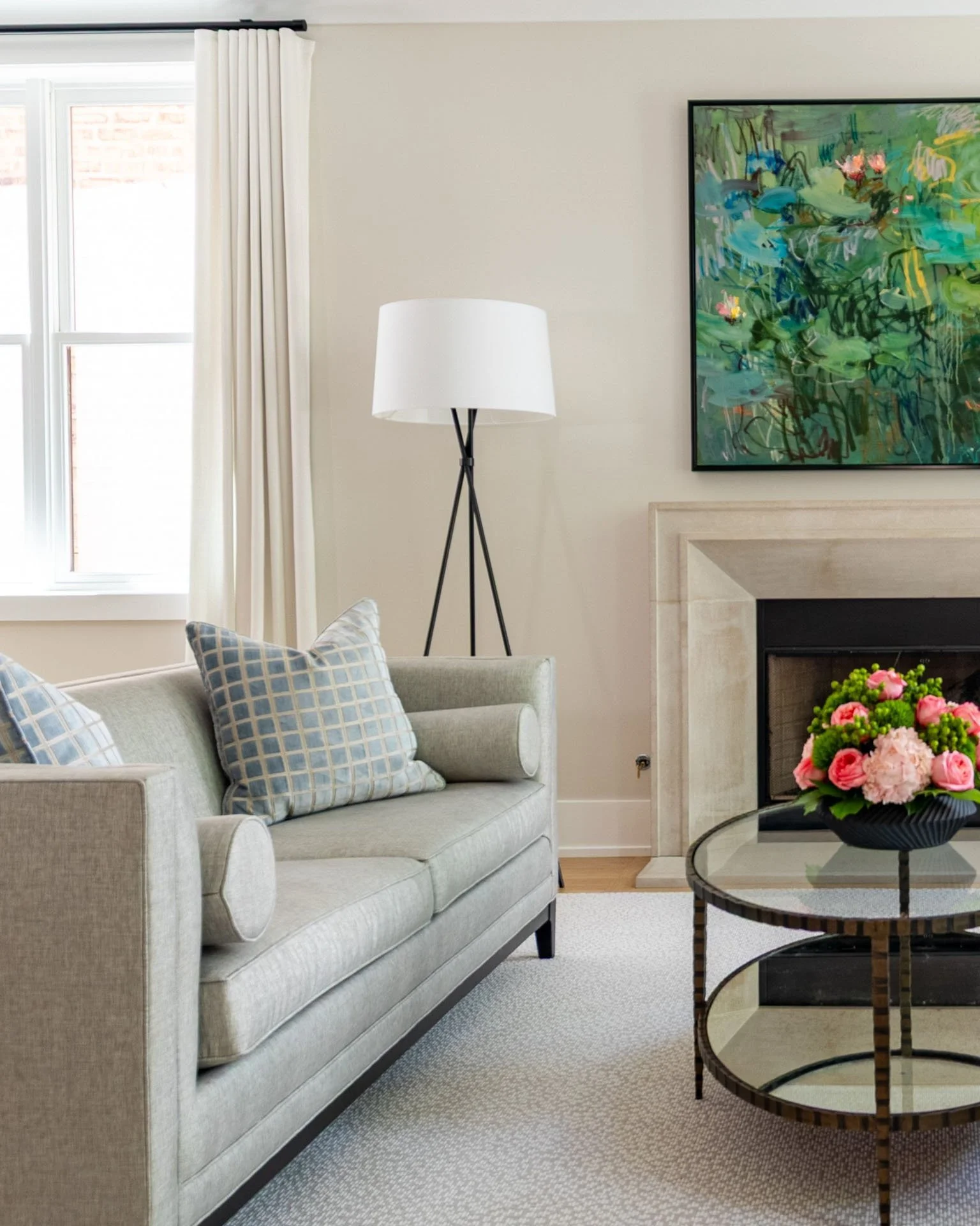 Roscoe Village living room with gray sofa, fireplace, and abstract artwork designed by Wendy Nobriga Interiors