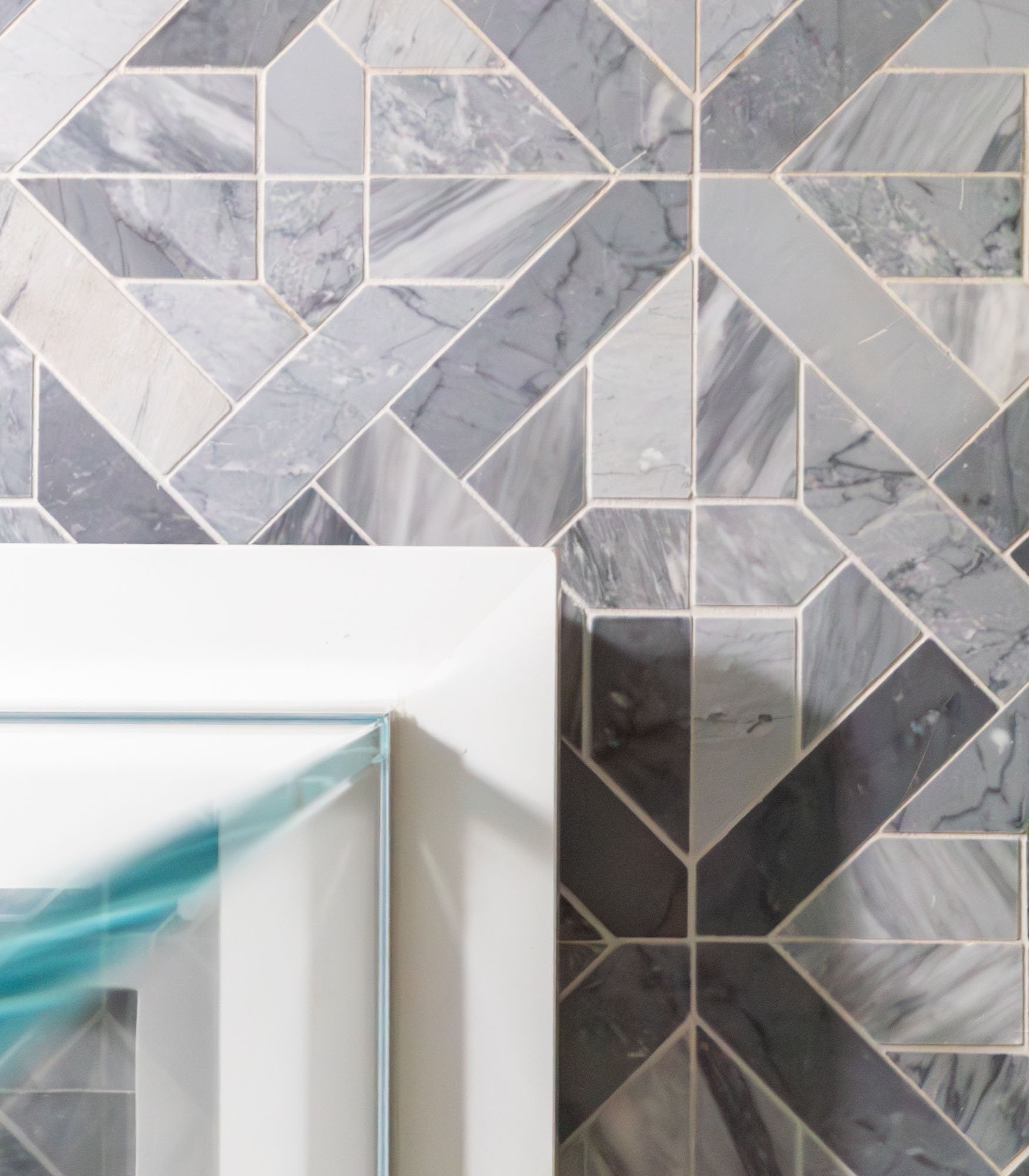 Marble tile bathroom floor and glass shower detail in Northbrook, Illinois. Design by Wendy Nobriga Interiors.