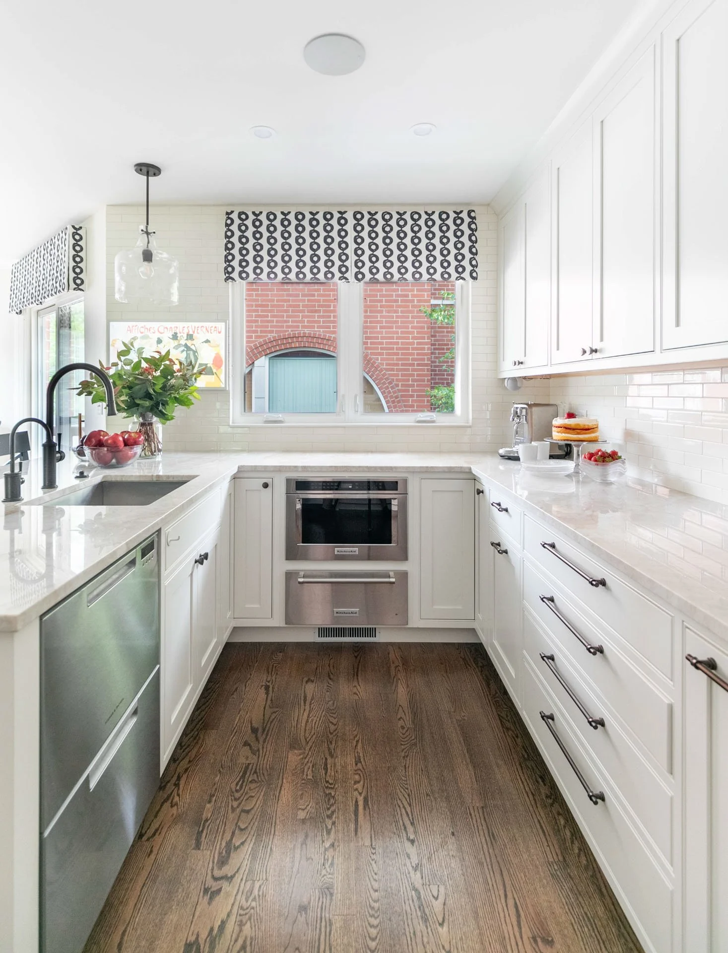 Des Plaines IL kitchen with quartzite countertops, stainless steel appliances, white cabinetry, and patterned window valances by Wendy Nobriga Interiors