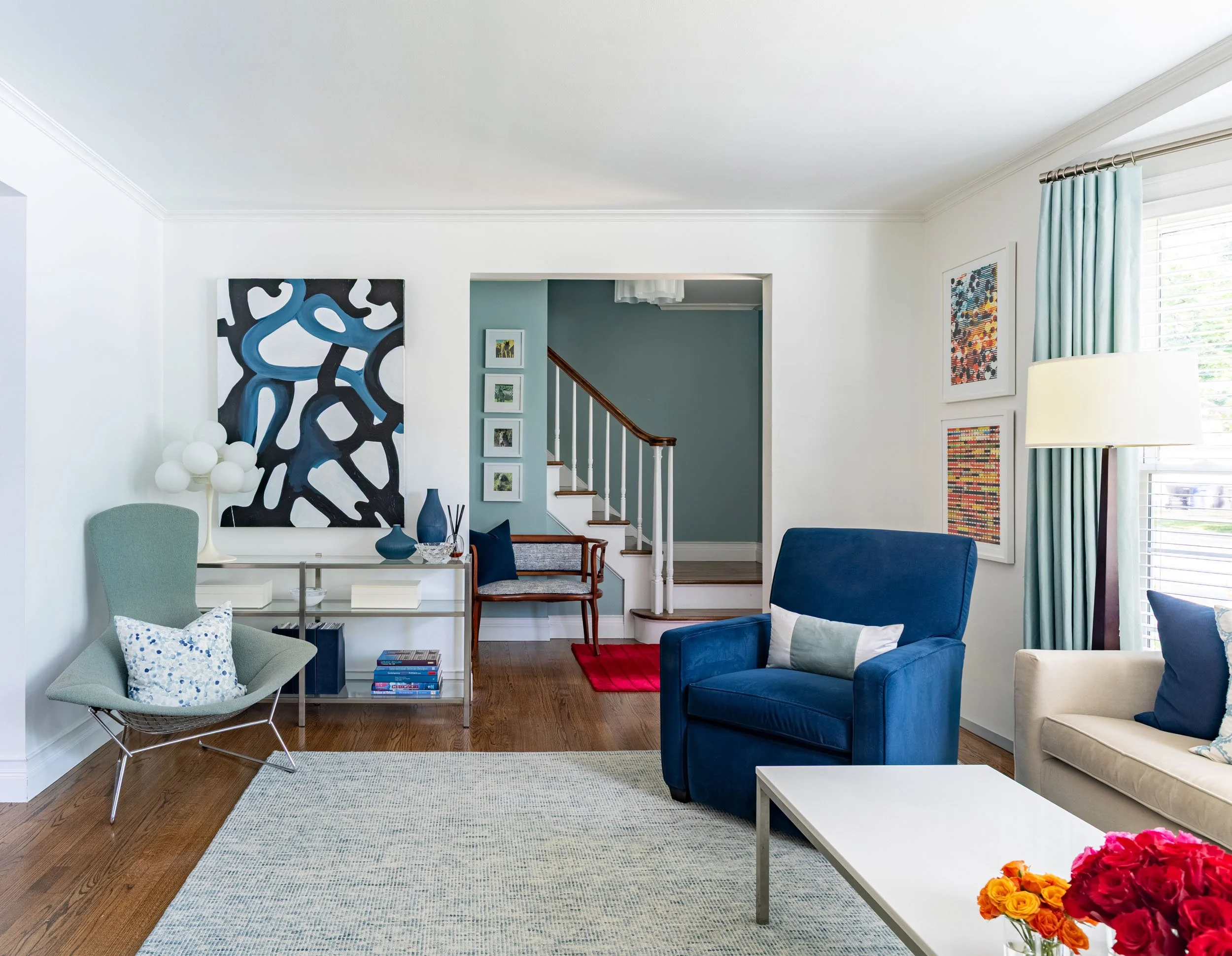 Modern living room in Edgebrook, Chicago, IL with open layout, custom furniture plan, and view to staircase. Design by Wendy Nobriga Interiors.