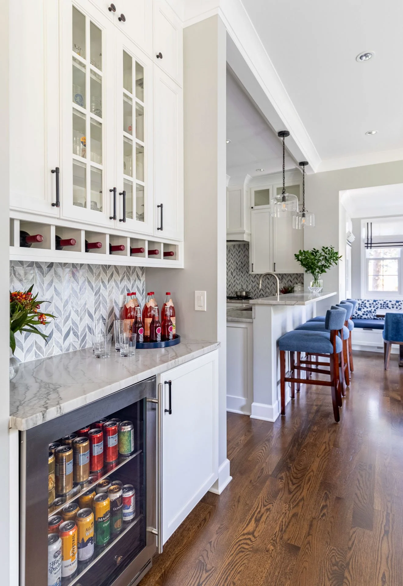 La Grange IL kitchen bar area with quartzite countertop, glass cabinet doors, wine storage, and beverage fridge by Wendy Nobriga Interiors.