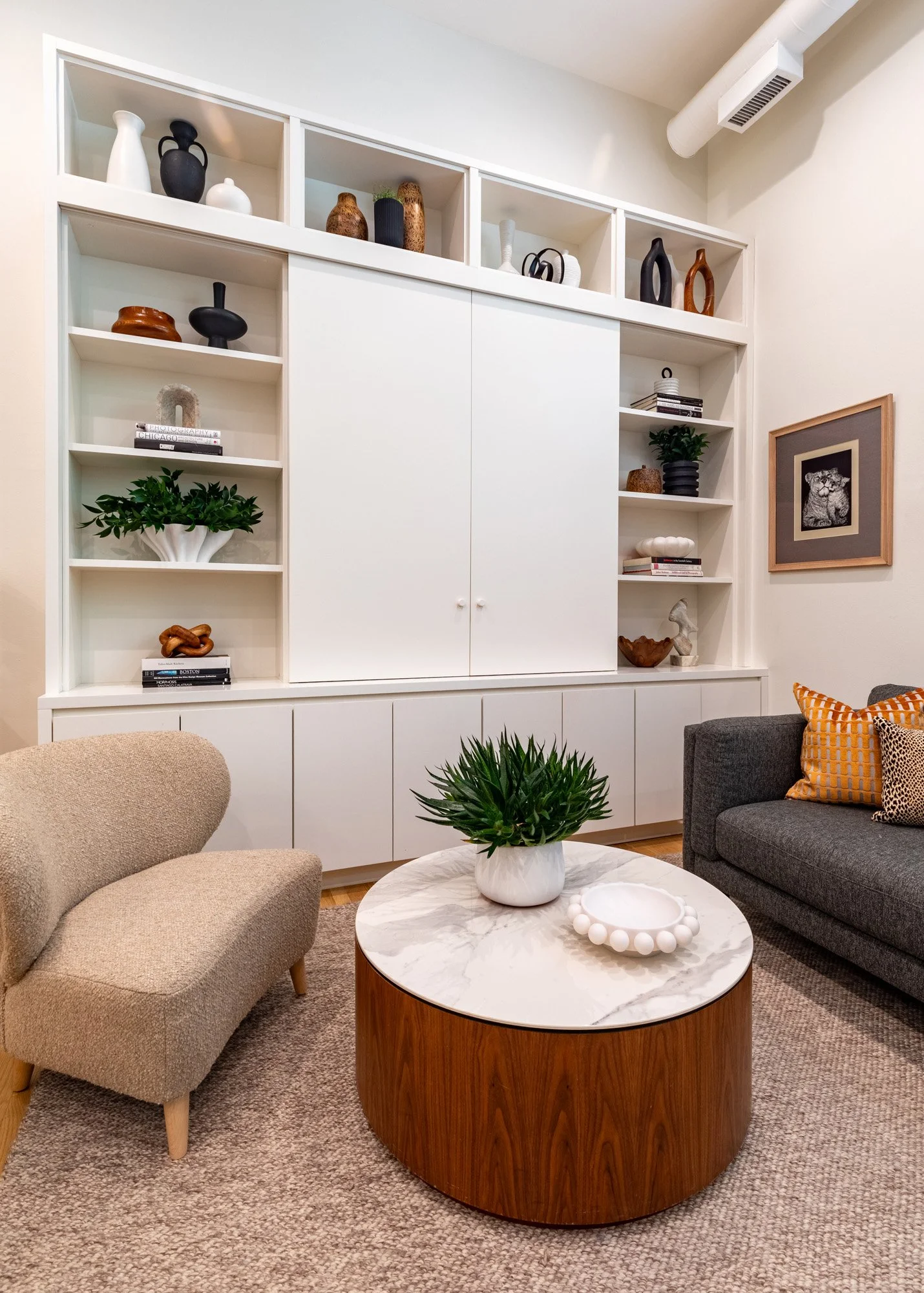Lincoln Park, Chicago modern living room designed by Wendy Nobriga Interiors featuring a custom media wall with concealed television doors, open shelving, and integrated storage.