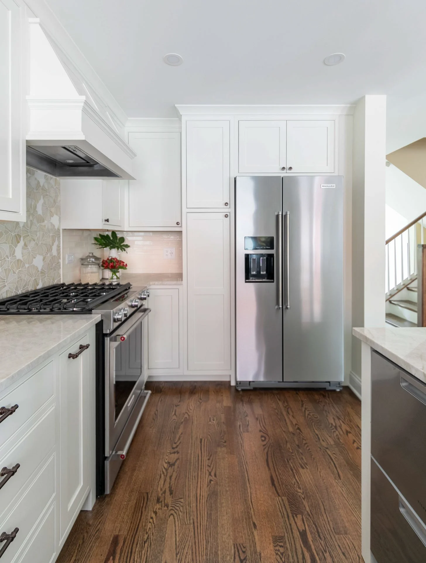Des Plaines IL kitchen with stainless steel refrigerator, gas range, quartzite countertops, and white cabinetry by Wendy Nobriga Interiors