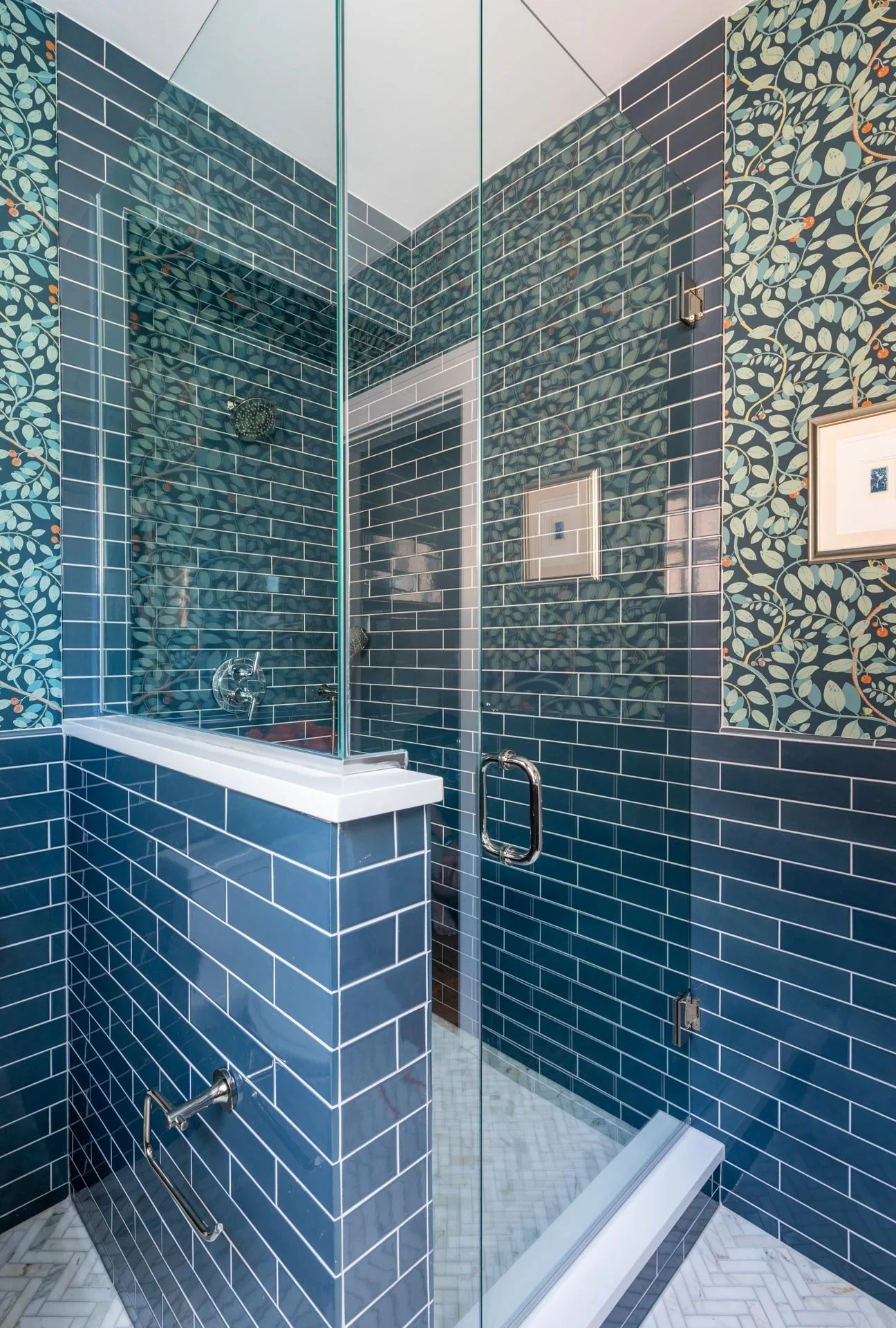 Lake Forest IL bathroom with glass shower enclosure, navy subway tile walls, and patterned wallpaper designed by Wendy Nobriga Interiors.