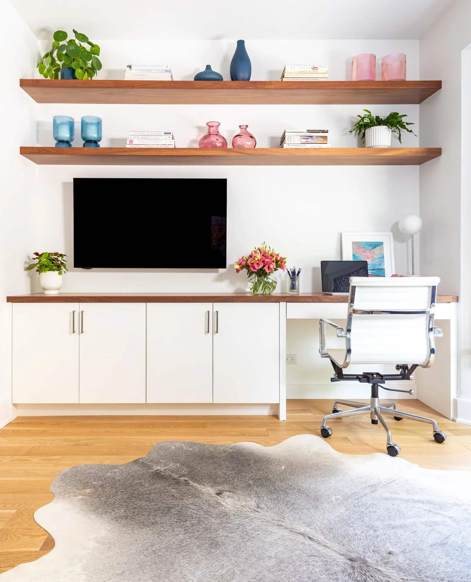 Wildwood Chicago IL home office with floating shelves, built-in desk, white chair, and wall-mounted TV styled by Wendy Nobriga Interiors.