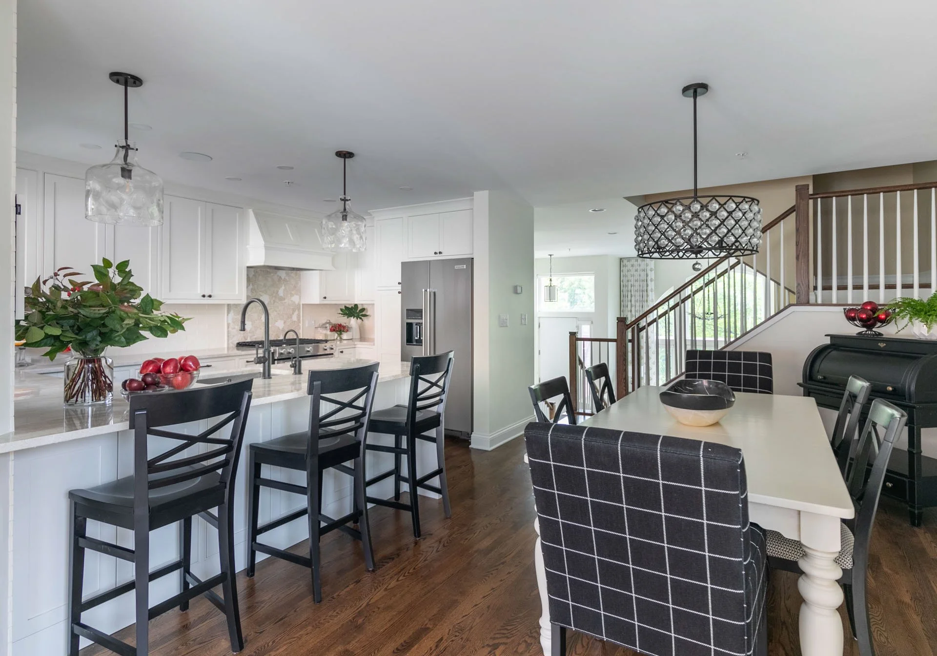 Bright kitchen and dining area with quartzite countertops, white cabinetry, and pendant lighting in Des Plaines IL by Wendy Nobriga Interiors