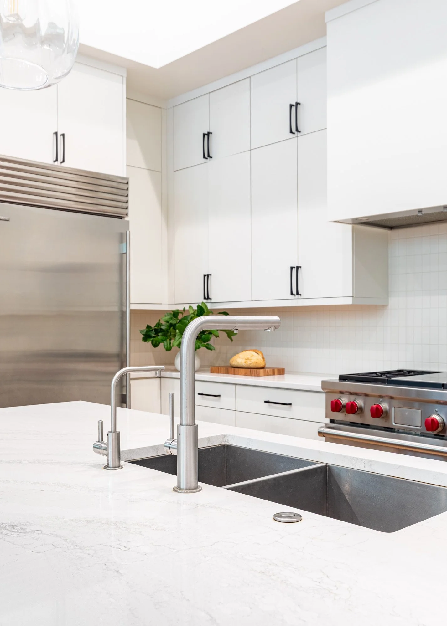 Lincoln Park, Chicago modern kitchen sink detail designed by Wendy Nobriga Interiors featuring quartz countertops, a workstation sink, and a contemporary faucet.