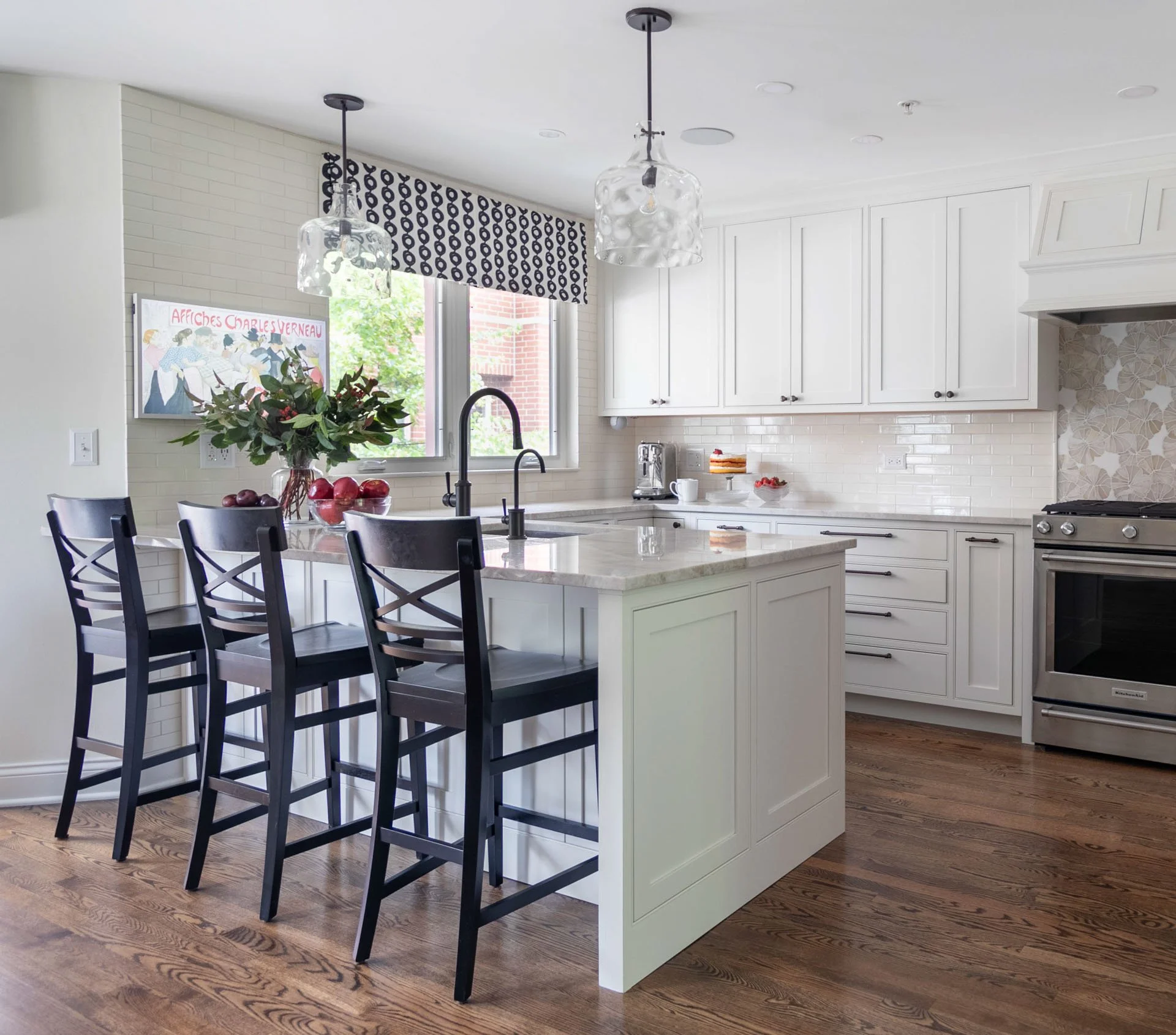 Kitchen peninsula with black barstools, white cabinetry, quartzite counters, and pendant lights in Des Plaines IL by Wendy Nobriga Interiors