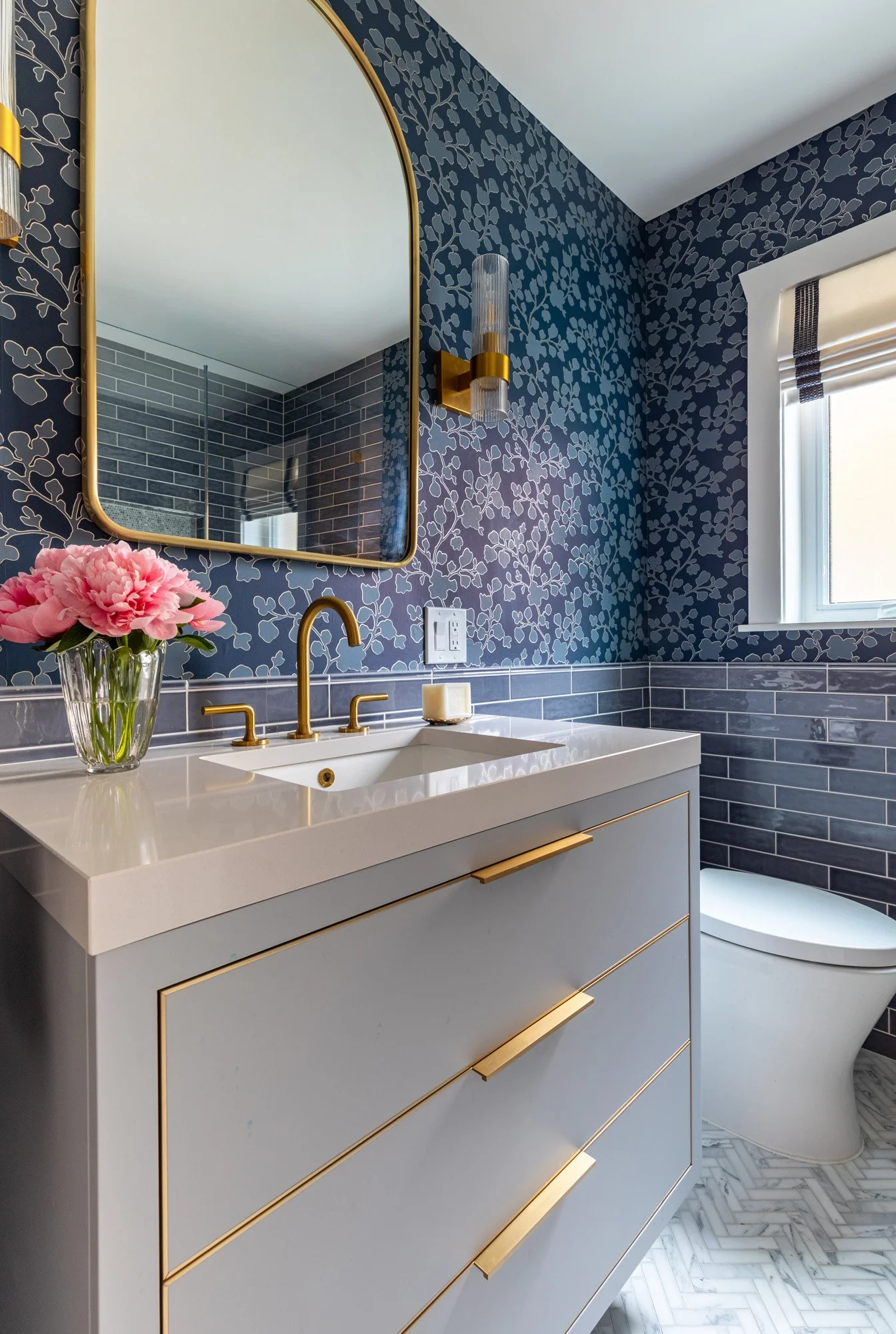Custom floating vanity in a North Edgebrook Chicago first-floor bathroom featuring quartz countertops, brass hardware, and contemporary design by Wendy Nobriga Interiors.