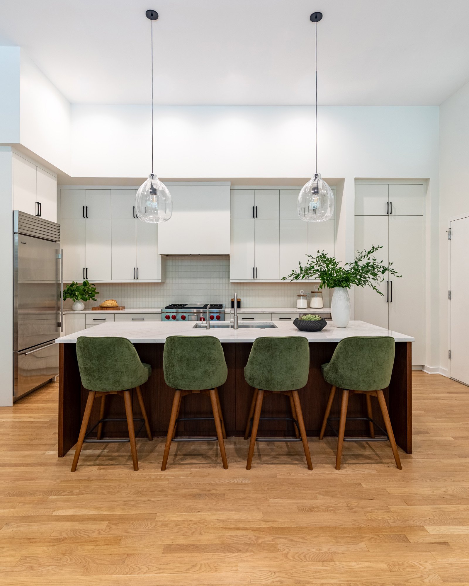 Lincoln Park, Chicago modern kitchen island designed by Wendy Nobriga Interiors with walnut cabinetry, seating for four, and quartz countertops.