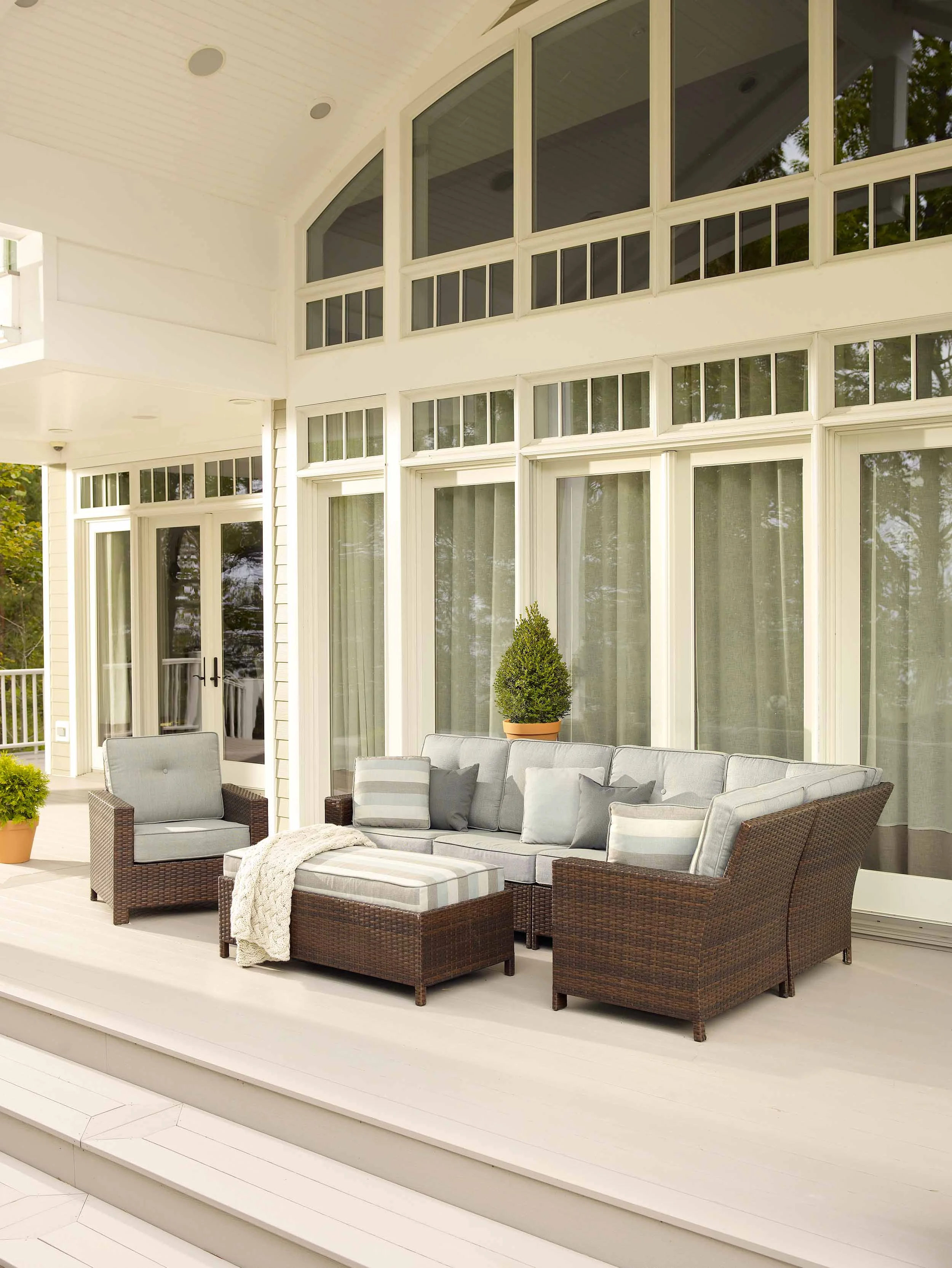  Outdoor furniture on large patio with tall windows 