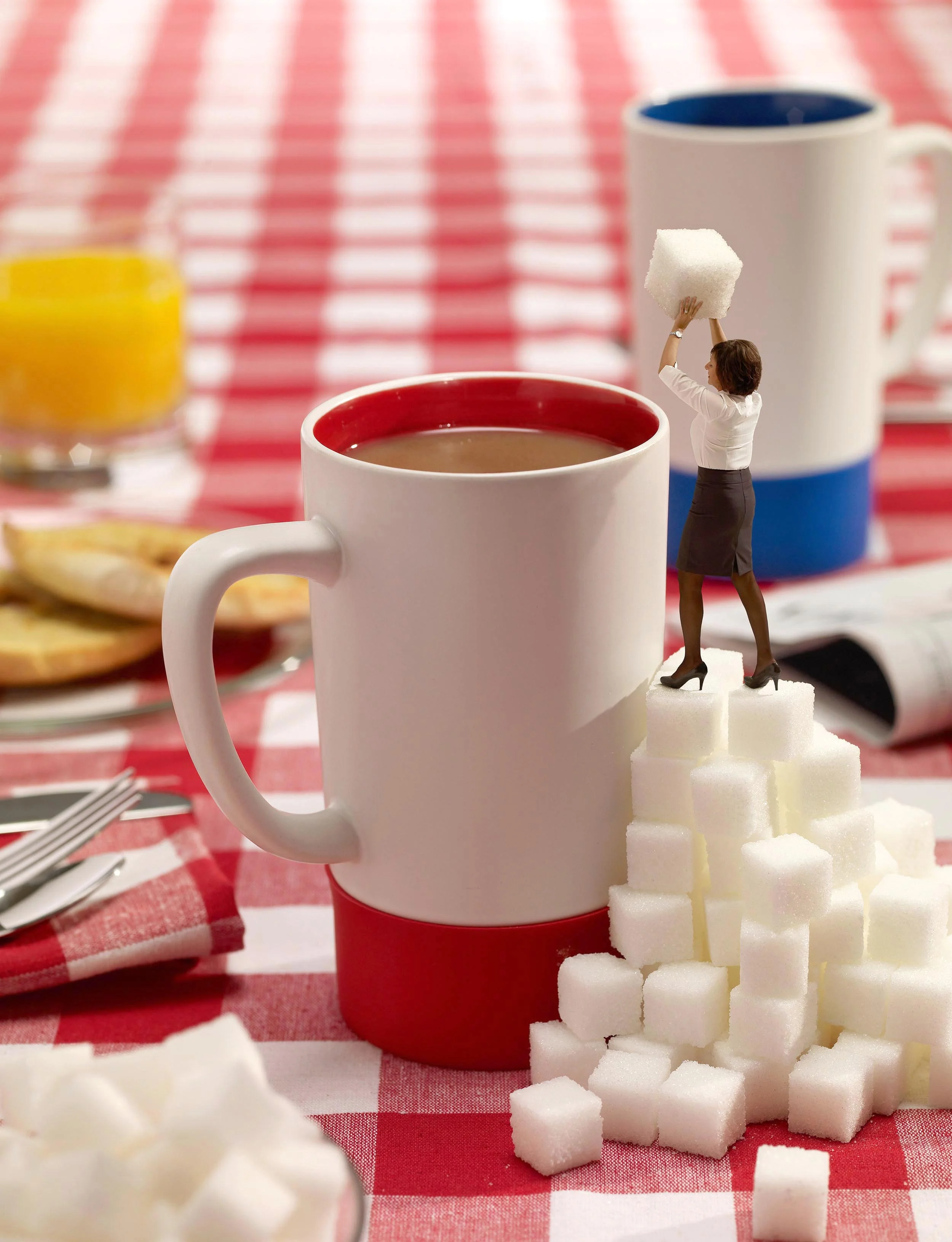  Miniature woman tossing a sugar cube into a coffee 