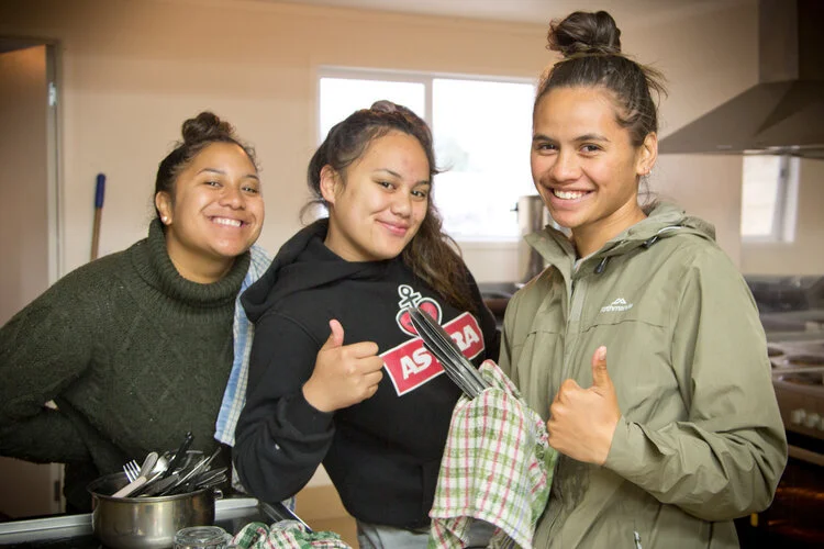 Ringawera at work in Tauanui Marae.  Queenie (Whakatāne), Chanel (Kaikohe), and Jazaire (Kaikohe) helping out in the kitchen on the first day of the Hui.