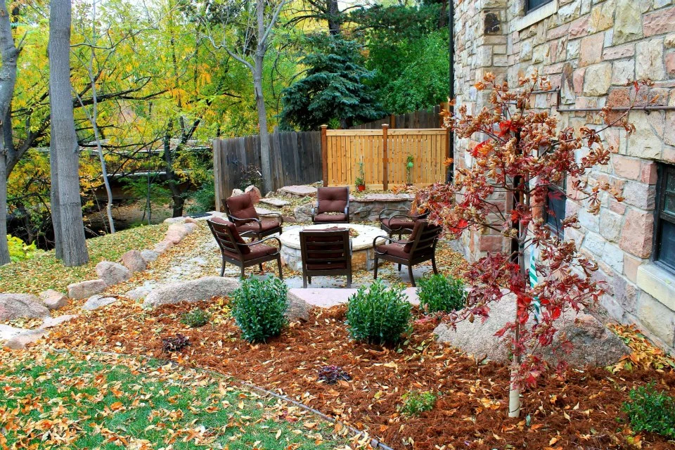 natural backyard with boulder and stone fire pit