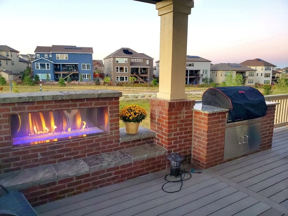 beautiful custom brick outdoor fire place and kitchen