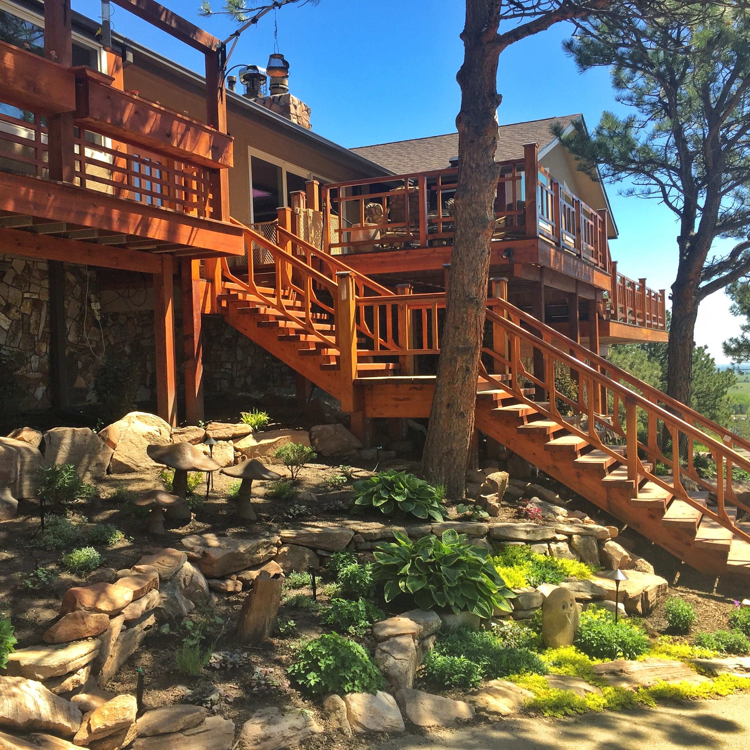 custom cedar deck and staircase with stone retaining walls