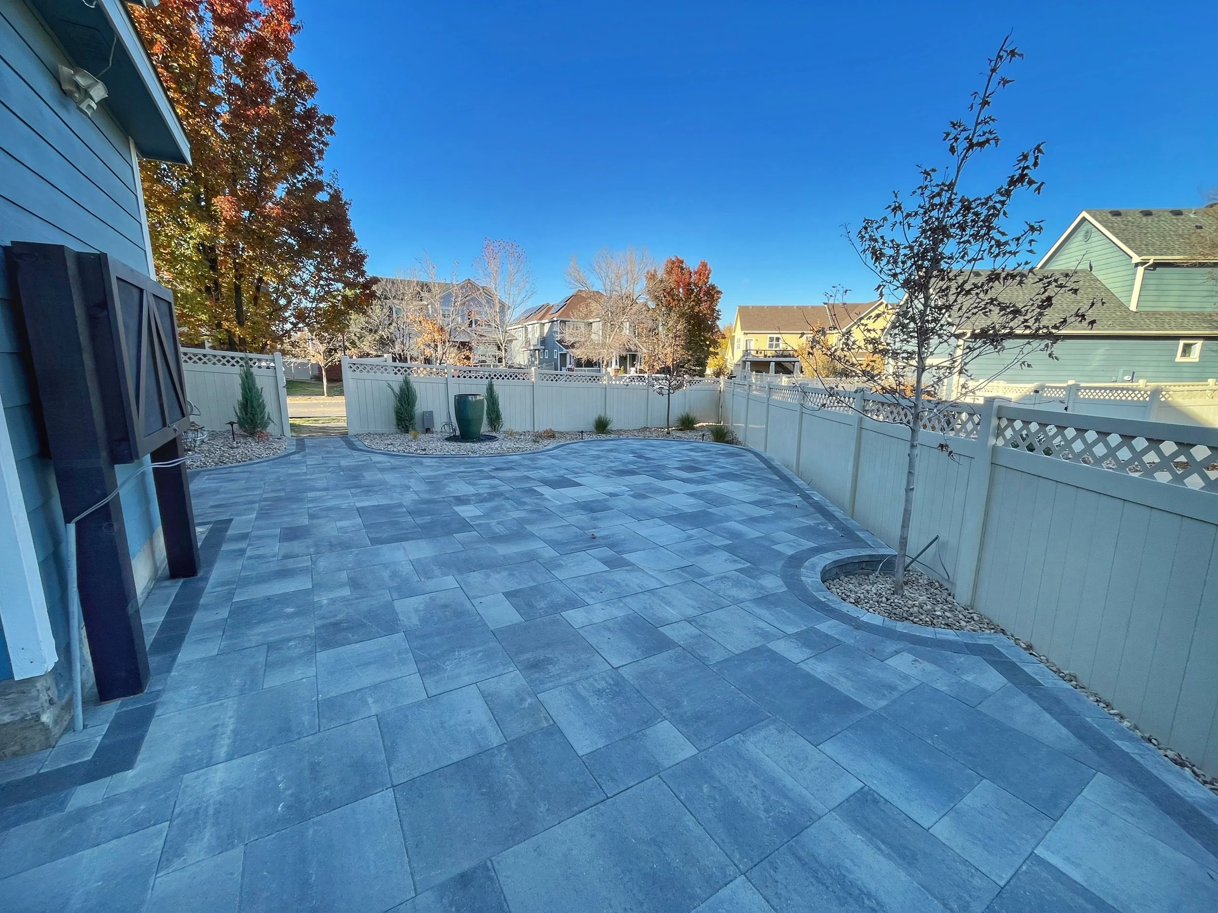 large custom paver patio outlining trees