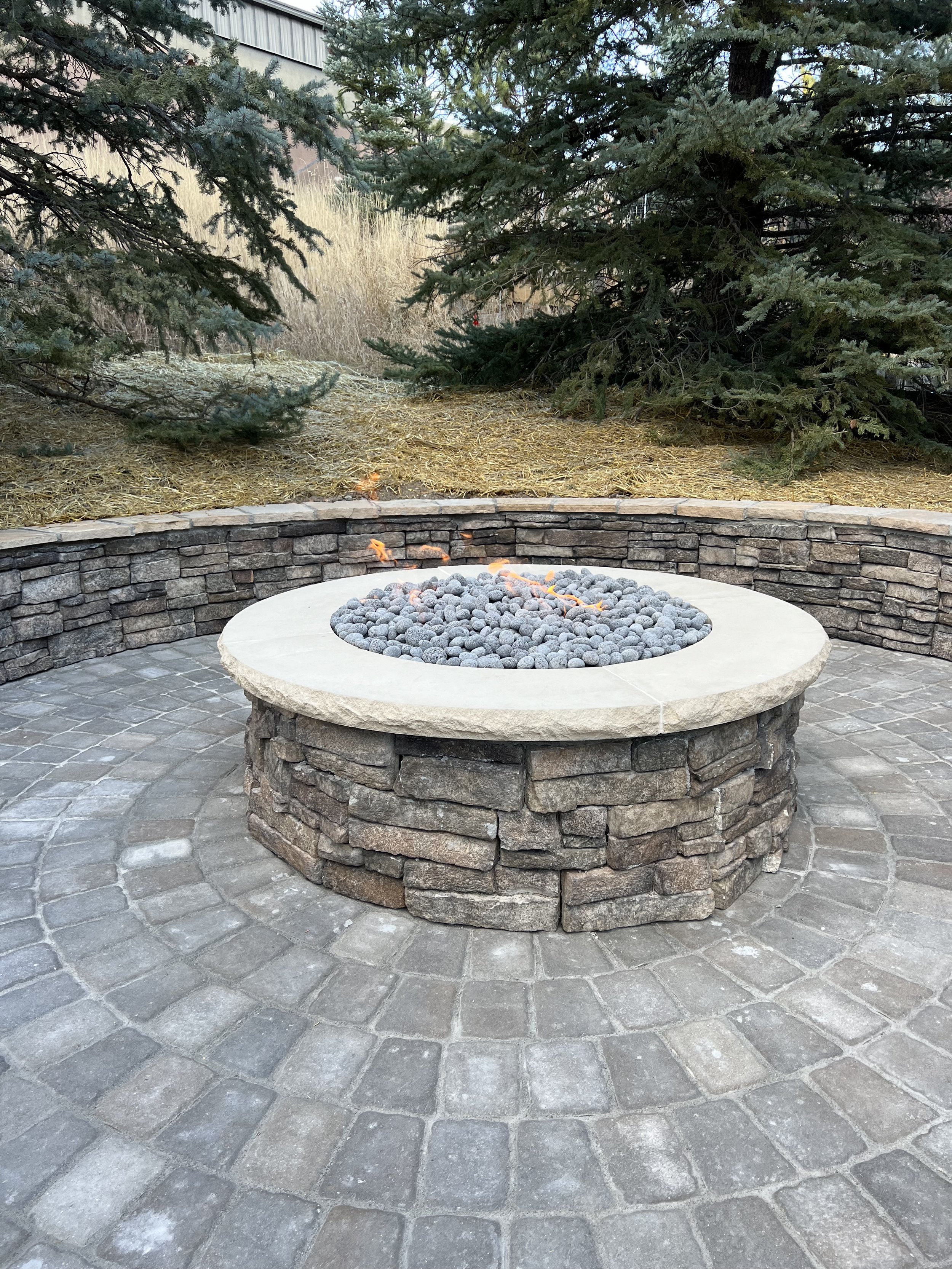 custom circular stone fire pit with surrounding stone wall