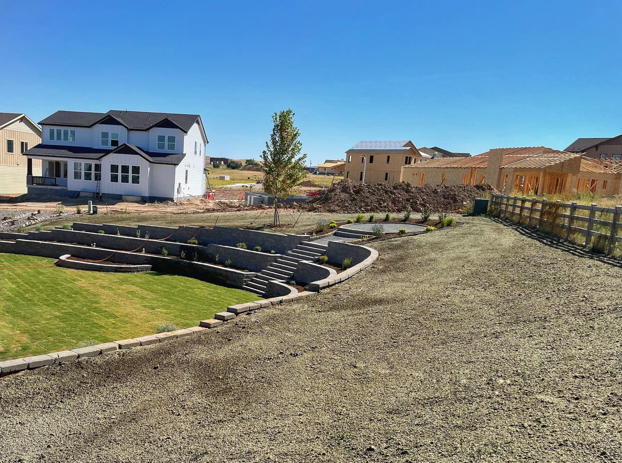 multi level retaining wall garden and stair case with circular paver patio