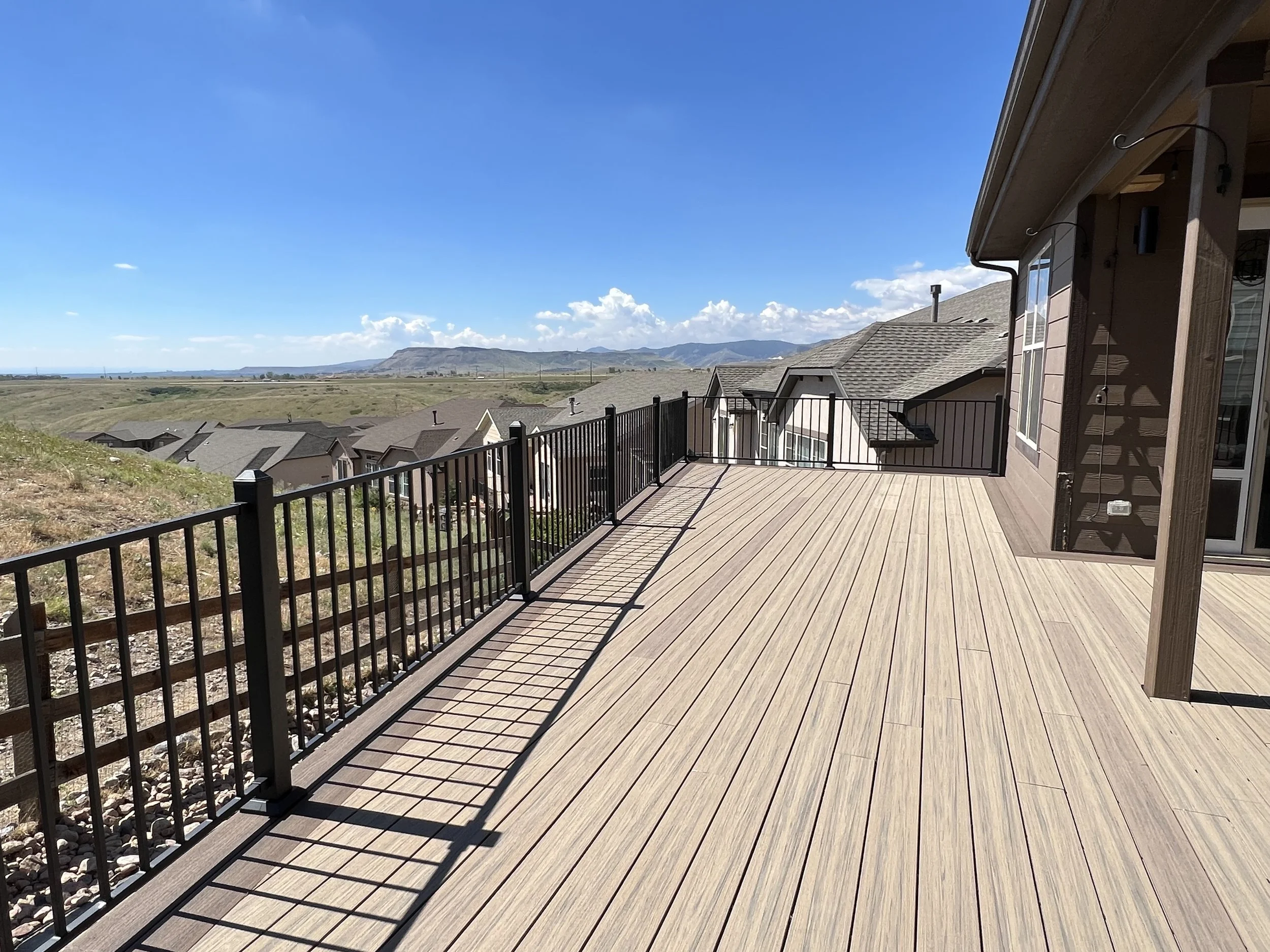 large custom multi level composite deck with iron railing