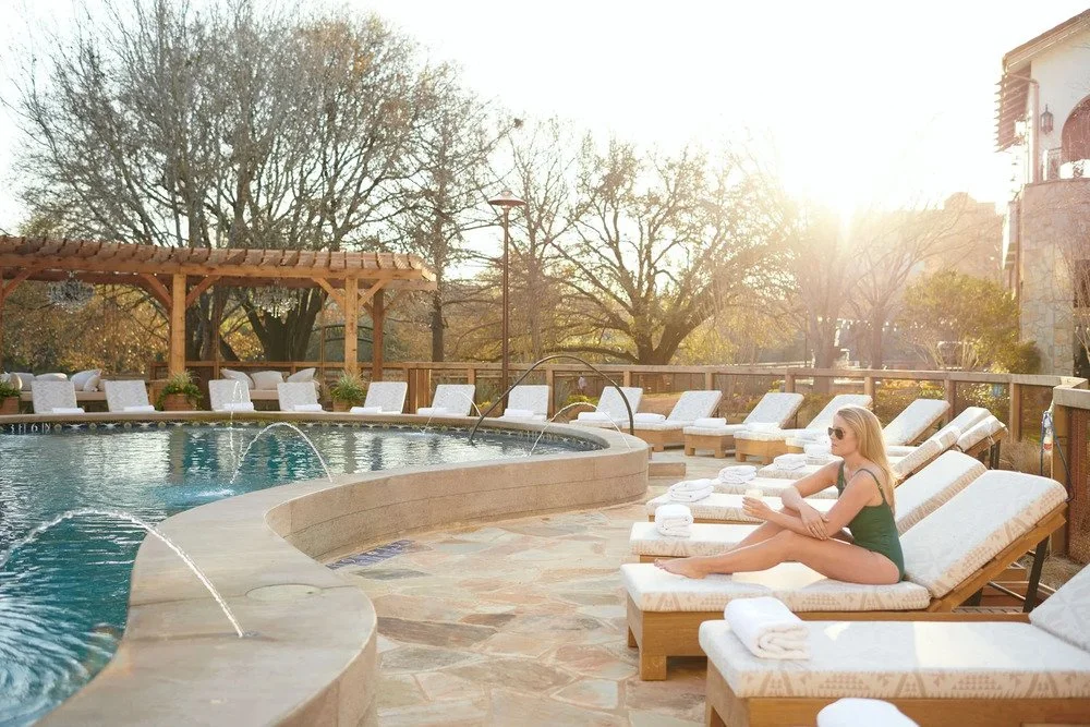 Model lounging beside a resort pool at sunset