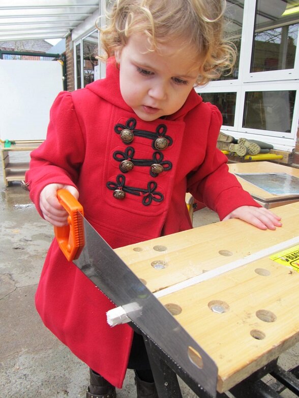 Young girl using handsaw