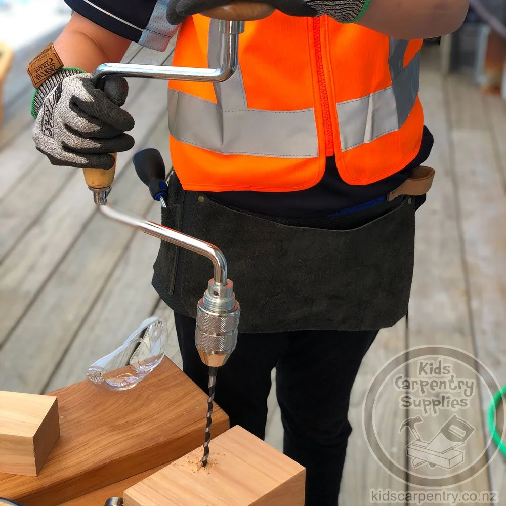 Child Using Brace And Bit Carpenters Drill To Make Hole In Wood
