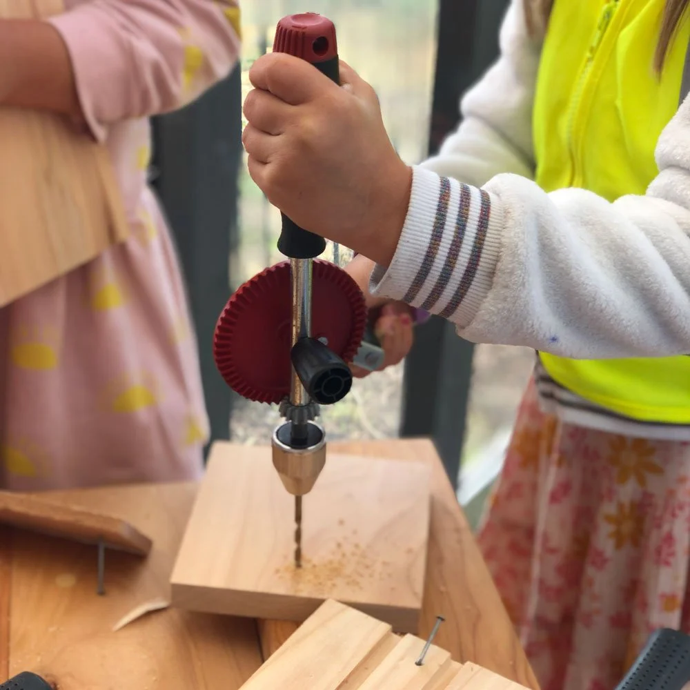 Young Child Using Manual Hand Drill for Carpentry Building Practice