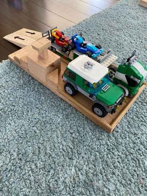 Handmade wooden toy car garage and parking station built by kids from timber offcuts
