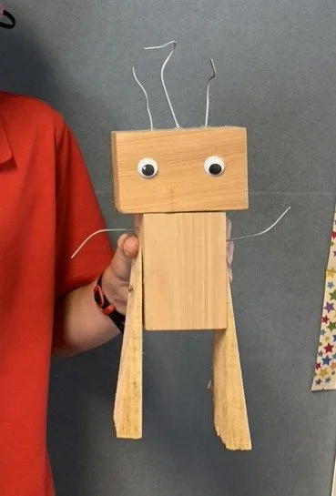 School boy holding Wooden Robot made in Multi-materials Technology Class
