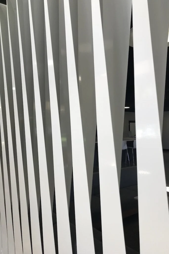  With  YAC  for Menlo College. I designed a series of steel fins to act as a separation between the low soffit of an entryway  into the larger expanse of a public meeting space. The fins were laser cut, and broken out of 11g steel. Each fin is made f