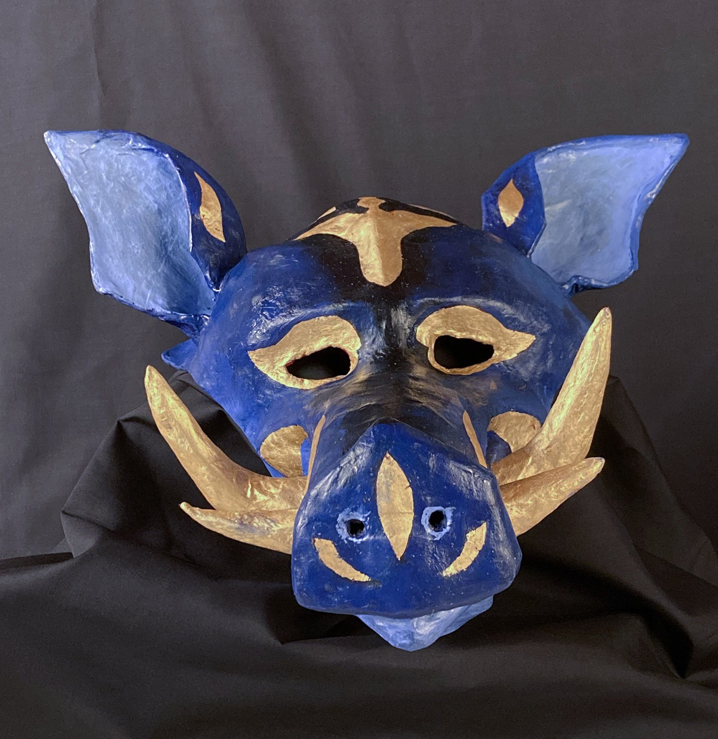    Warthog mask,  2022.  Oil paint and gold leaf over paper mache. 10” high (to top of head). 