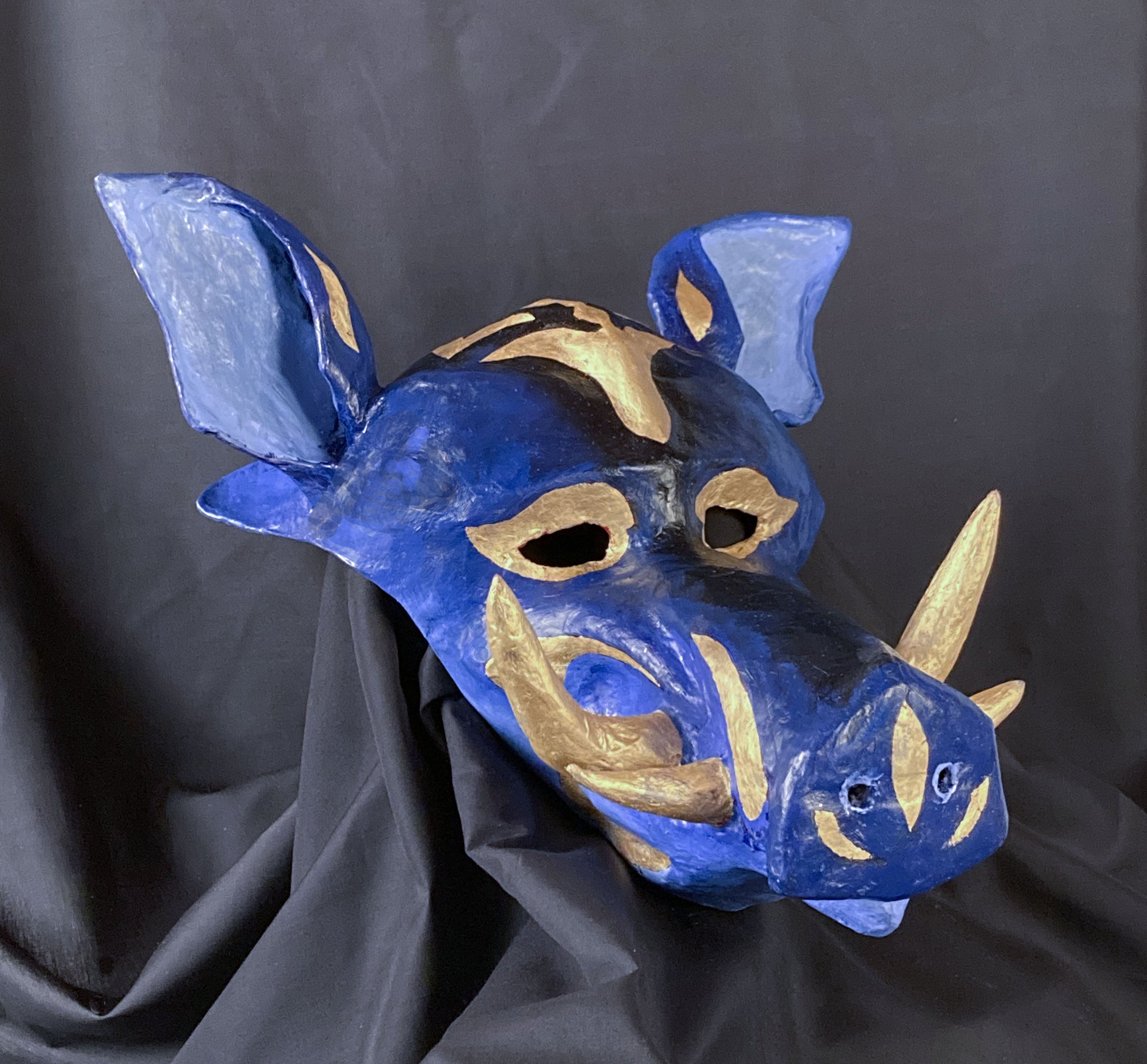    Warthog mask, view 2,   2022. Oil paint and gold leaf over paper mache. 10” high (to top of head). 
