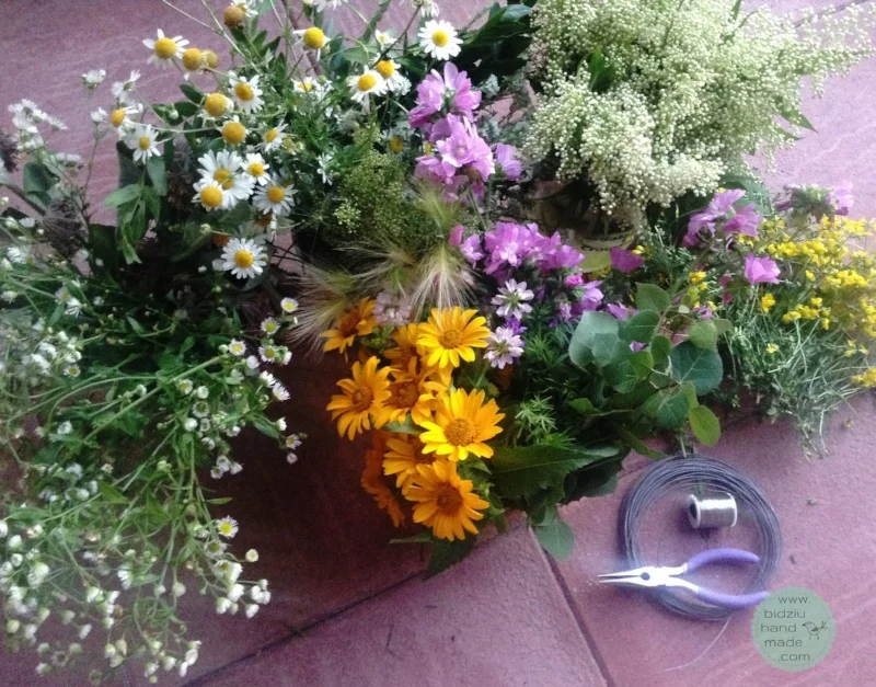 Assortment of grasses, leafy twigs, and wild flowers ready to be transformed into pretty flower crowns.