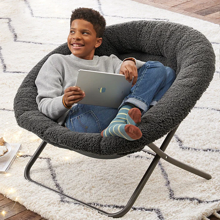  Boy sitting in a round gray chair with iPad 