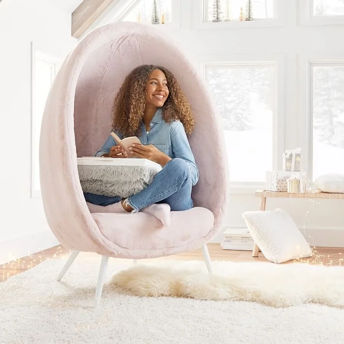  Girl sitting in a pink chair with a book 