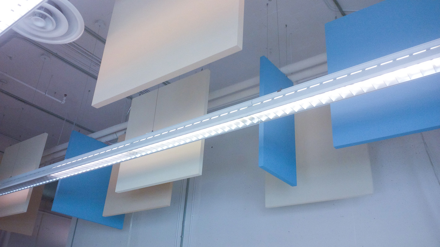 Sound absorbing baffles such as these can be installed post construction. Their exact location is not critical, which makes it easier to accommodate other elements—such as structure, sprinklers, ducts, and lights—that have very specific locations.