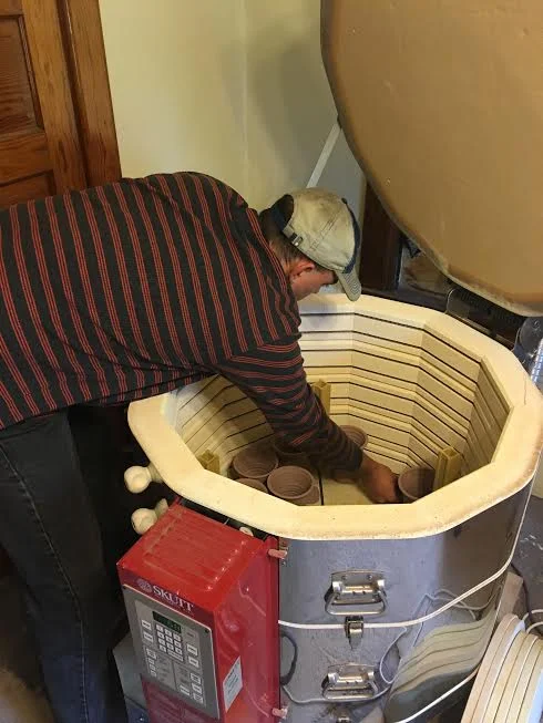 Josh loading pots, saucers and tags into the electric kiln, ready to preheat and fire!