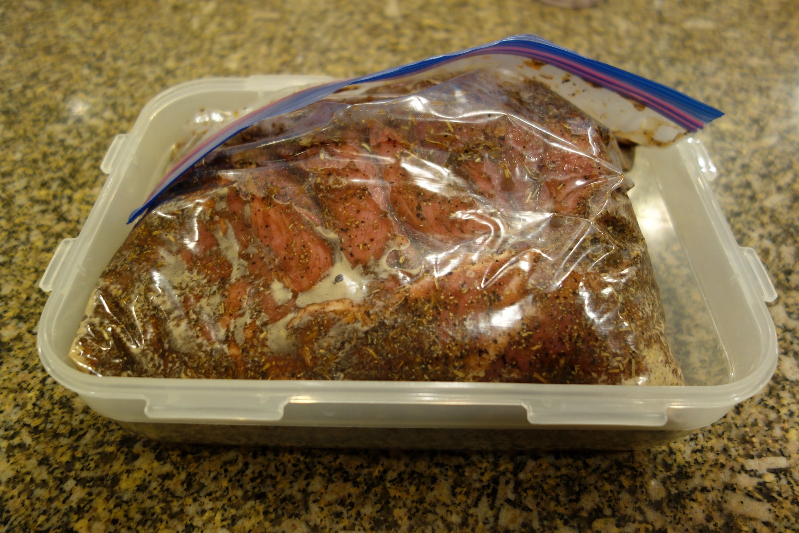 Marinate it in a plastic bag with the air squeezed out. Place it a container in the refrigerator overnight.