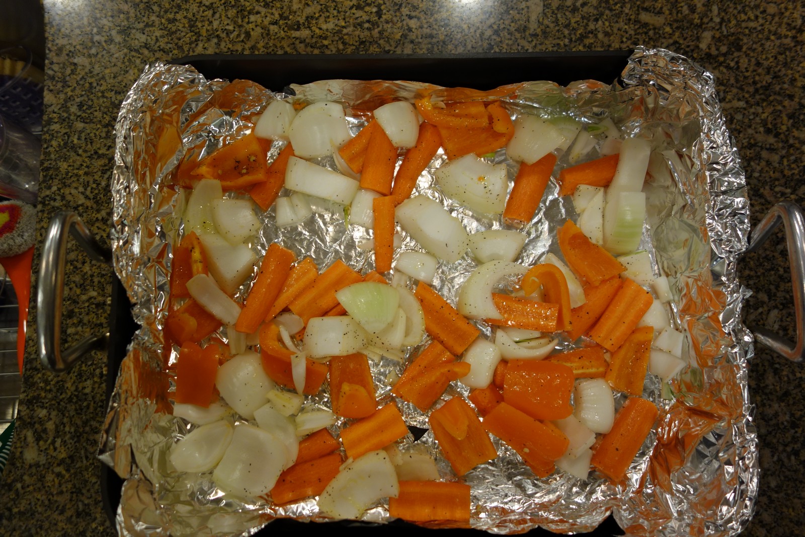 Put the carrots, onions, and peppers in a foil-lined roasting pan, then toss them in olive oil, salt, and pepper.