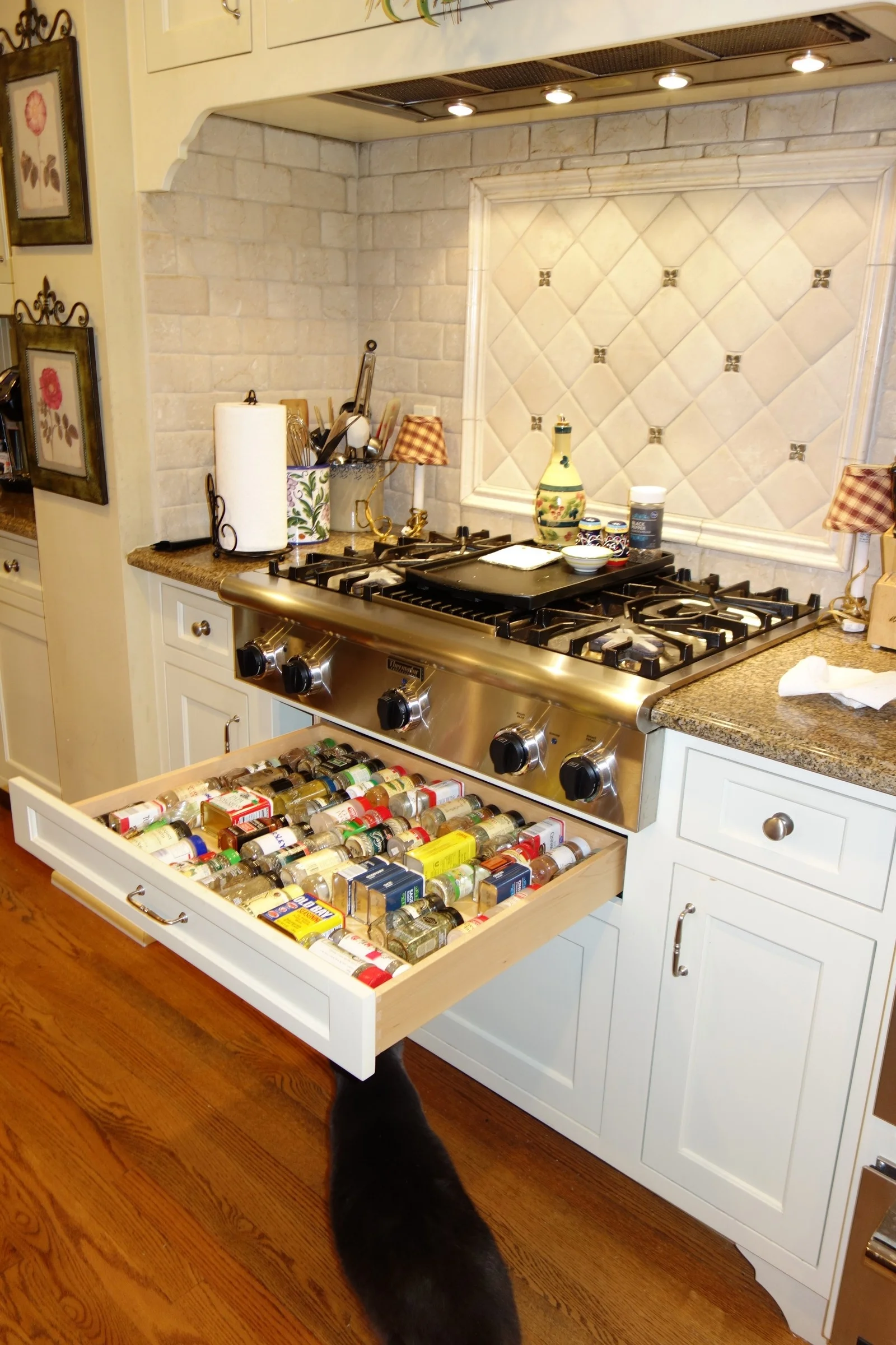 Our spice drawer is under the cooktop, over the cat, and just across from the island where we do our food prep. Works very well.