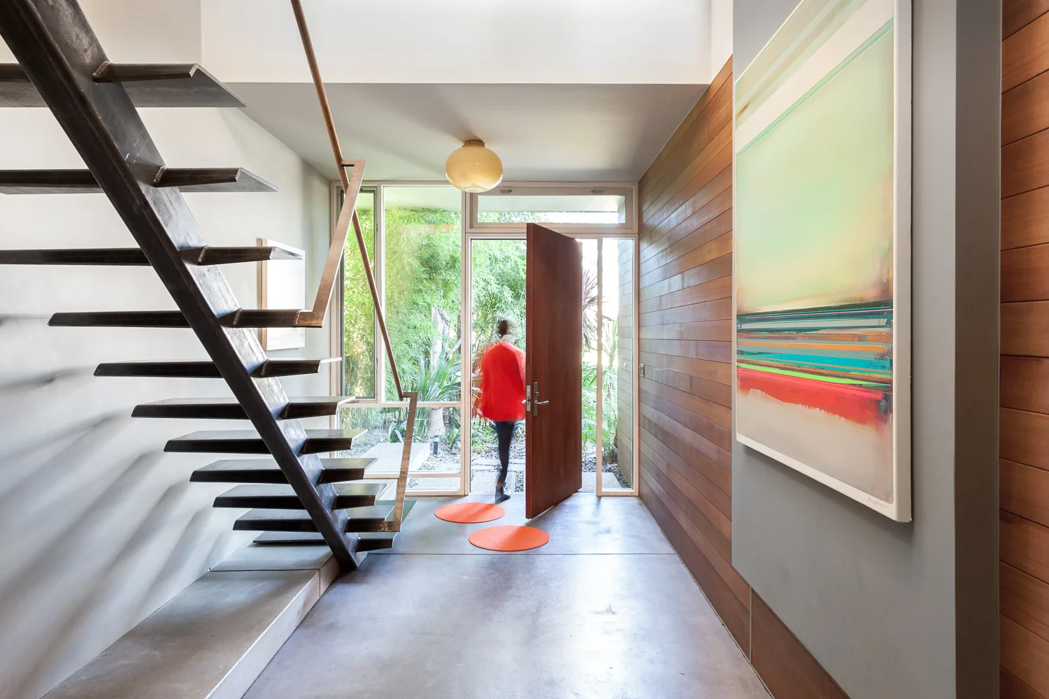A 4' wide mahogany pivot door is captured in glass. The cedar siding walks with you as you move inside to out.