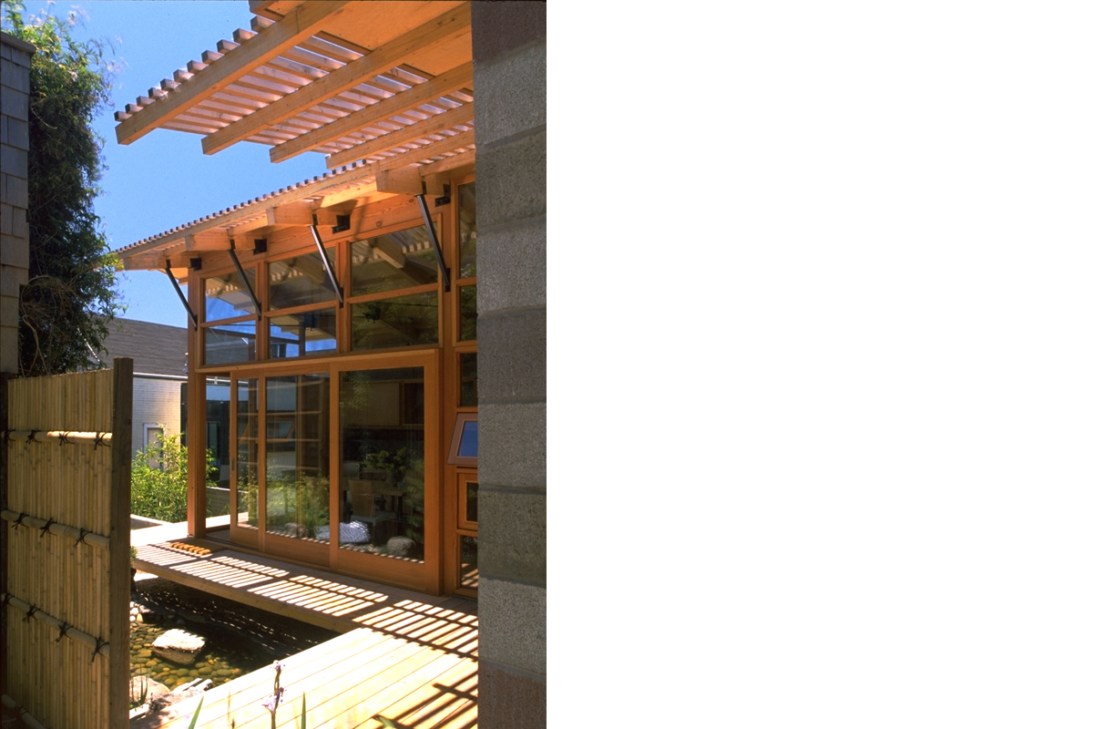 The warm cedar, polished concrete block and wide mahogany pivot door invite you in.