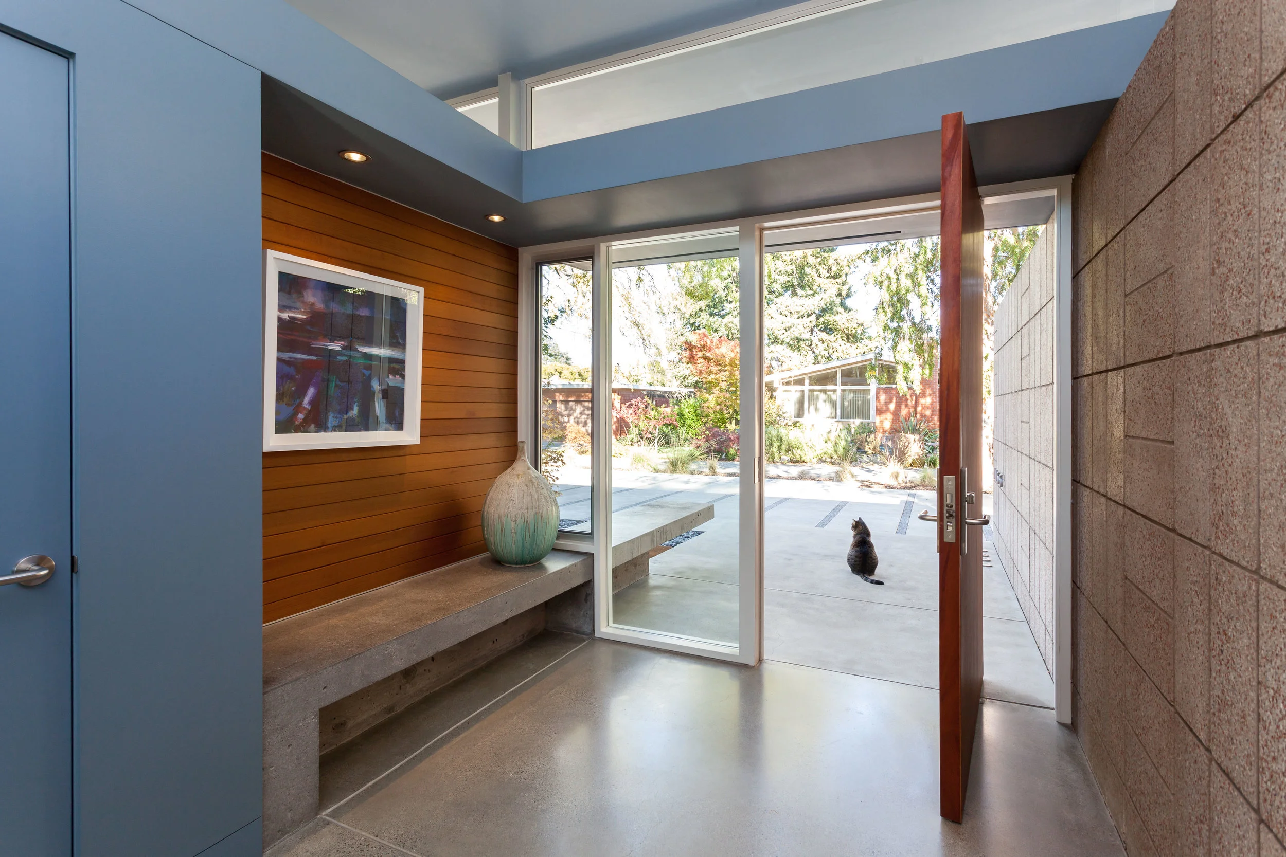 The cat stands guard. The polished block, concrete floors and the polished concrete bench all work to marry inside and outside.