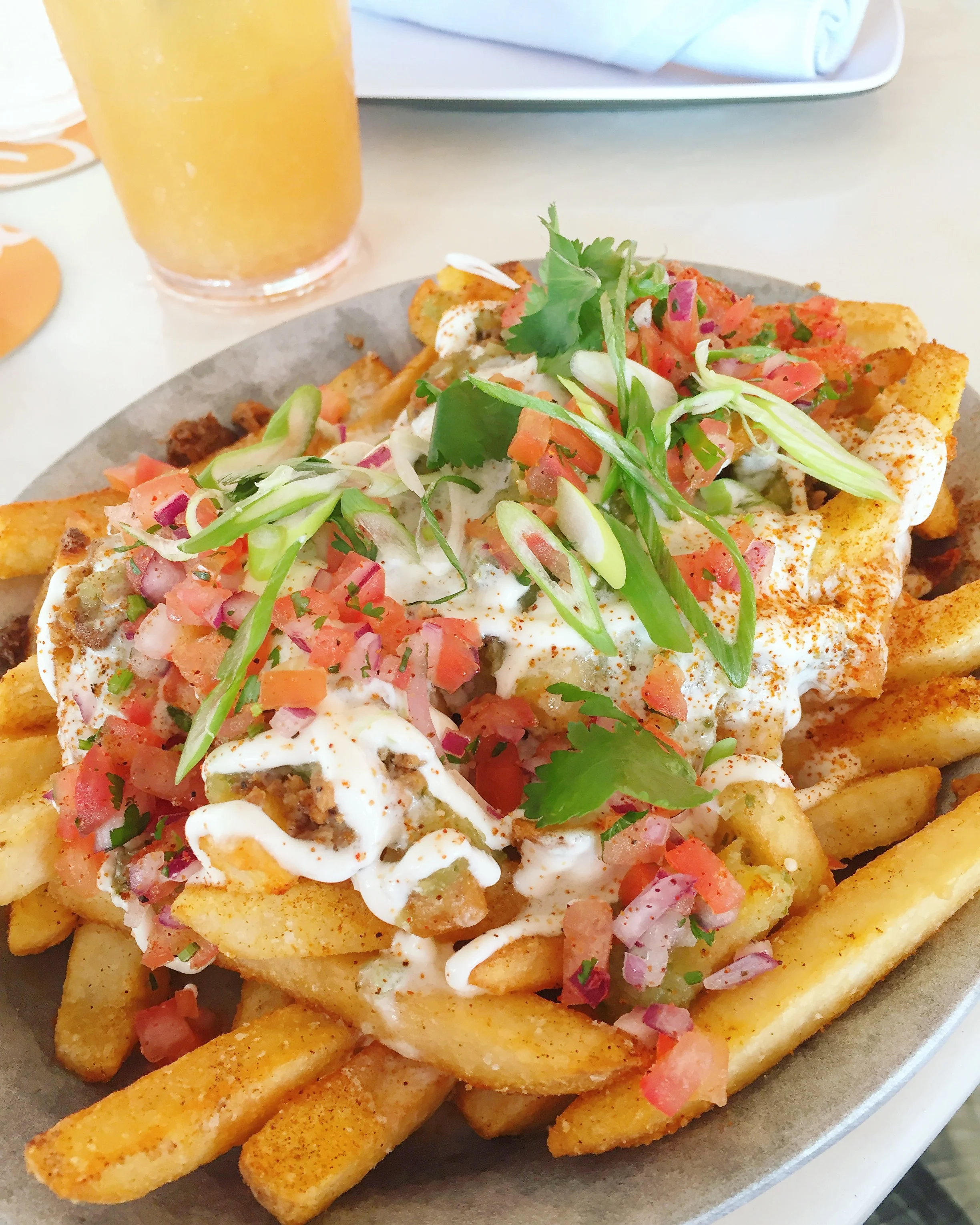 Mexi-poutine: fries, scallions, chorizo, pico de gallo, cilantro, crema, Oaxaca cheese & salsa verde