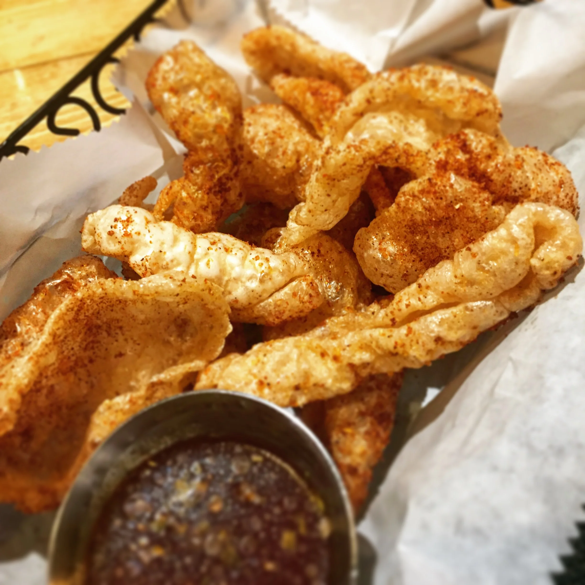 The Signature Chicharron Chips (aka crispy pork rinds) dusted with house made spices and served with an addictive cilantro chili vinaigrette