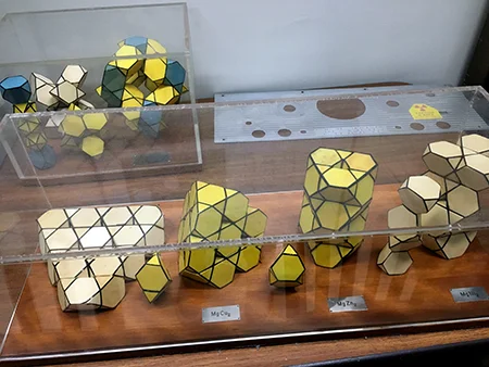 Polyhedron models of various intermetallic compounds (MgCu2, MgZn2, and MgNi2 in front). A common motif is the Friauf polyhedron represented by a truncated tetrahedron with four triangular faces and four hexagonal faces. Despite the simple formulas,…