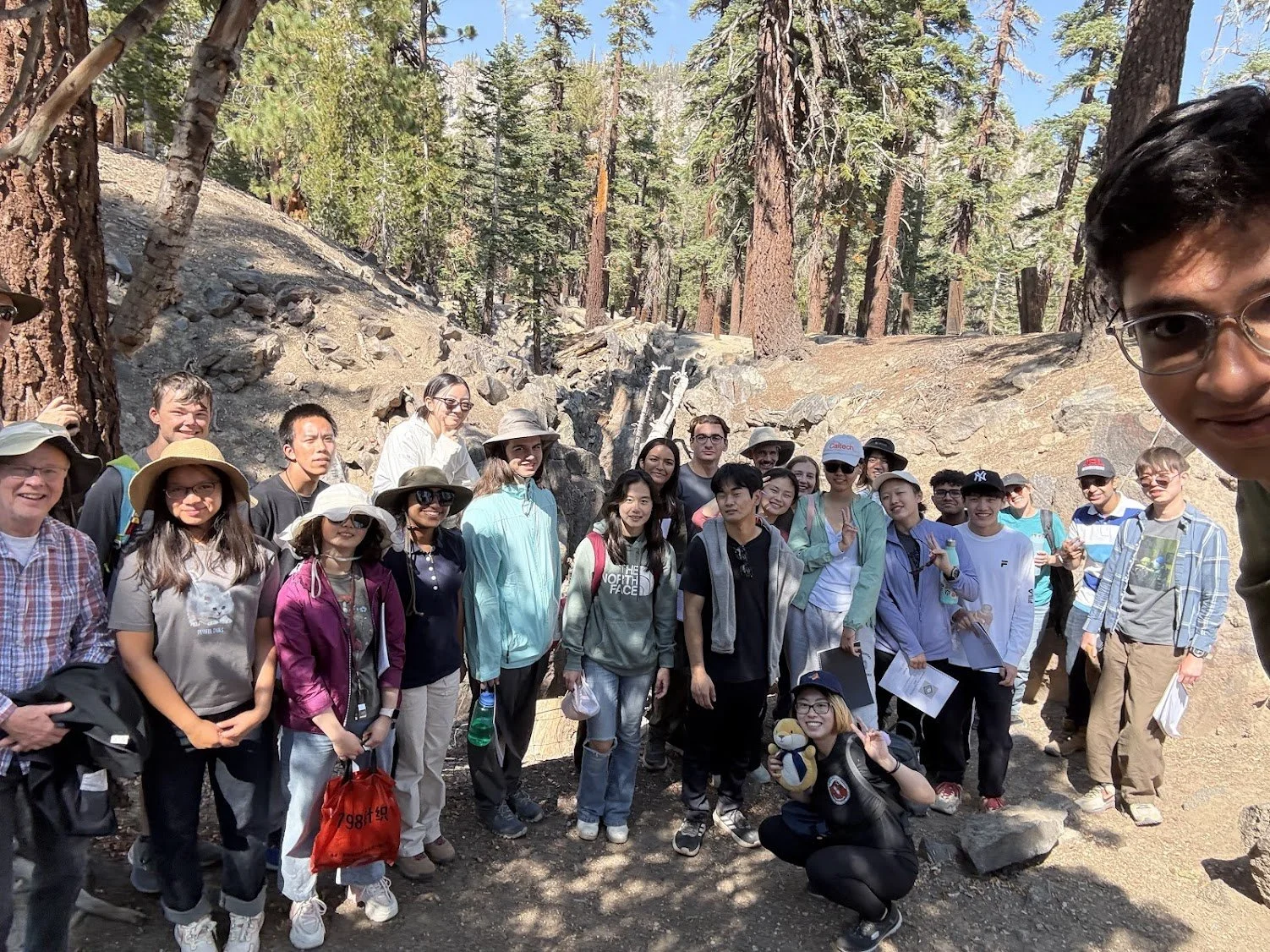  The integrated core students stand in front of the Earthquake Fault, a 60-foot-deep fissure through volcanic rock that opened some 600 years ago across what is now Highway 203 on Mammoth Mountain. Credit: Vedant Ganesh 
