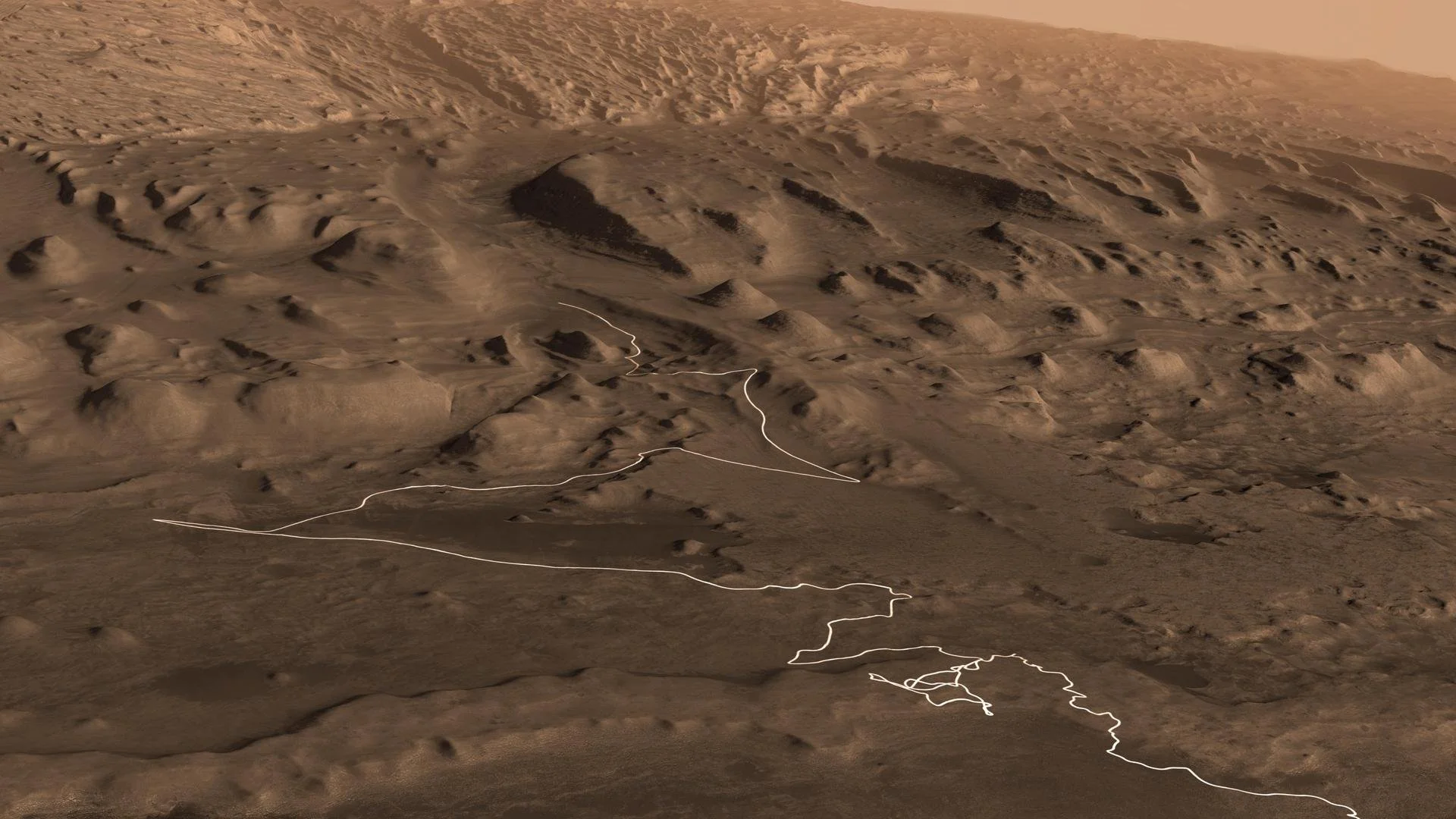 Map view of lower Mount Sharp on Mars showing Curiosity rover’s proposed driving route traced in white across dunes and ridges, highlighting regions scientists plan to explore.