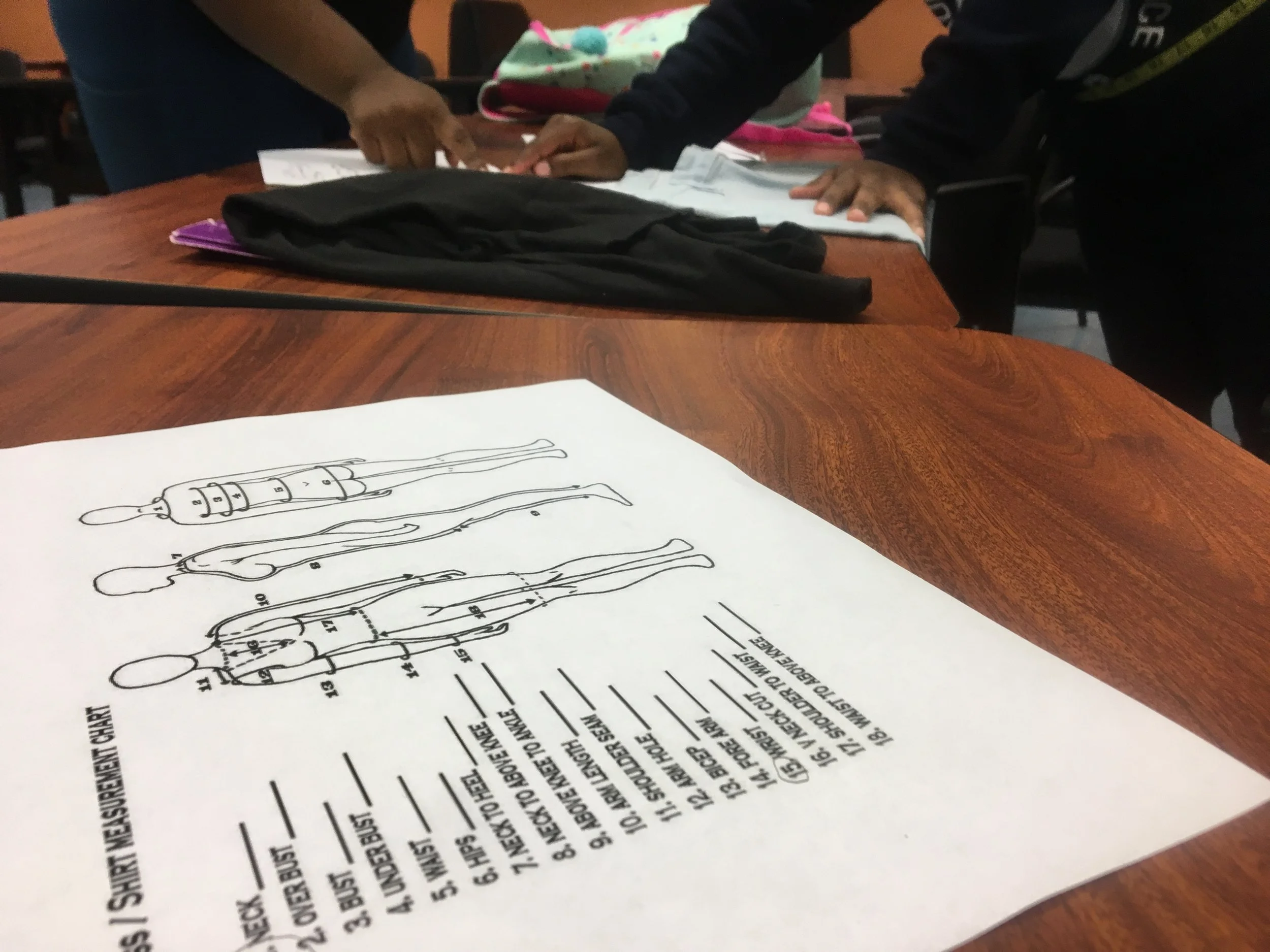 Students practice taking measurements before working on their fashion show pieces. (Picture by Dylan Deprey)